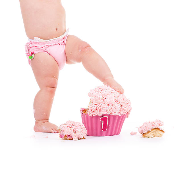 istock baby in pink standing on pink birthday cake 514788514