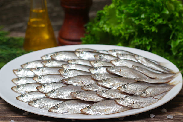 istock Salted sprat fish with greens on a plate 514788830