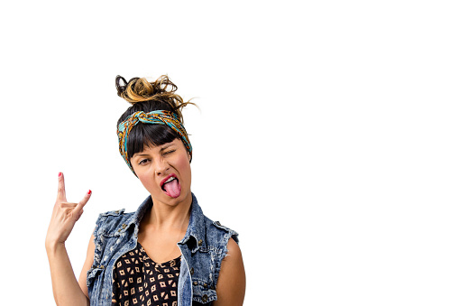 Portrait of young latin woman dressed casual making silly faces showing her tongue.