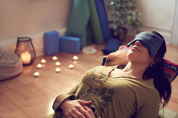 Serene lady relaxing and meditating on a yoga mat in a cosy house