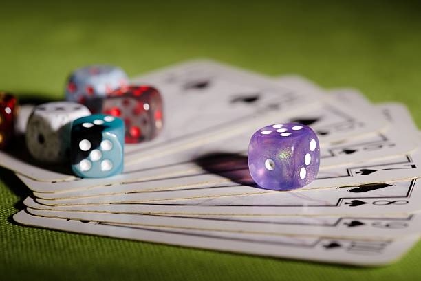 istock Purple dice on used playing cards 514792382