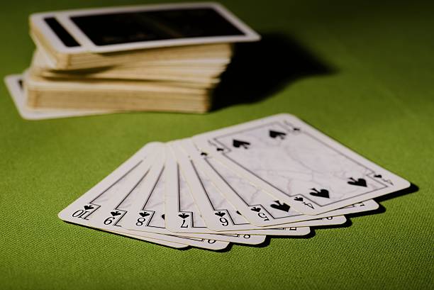istock Used playing cards on green carpet 514793086