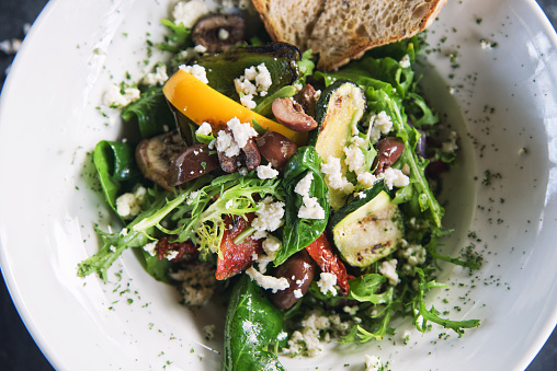 Top view of rocket salad with grilled vegetables and feta cheese