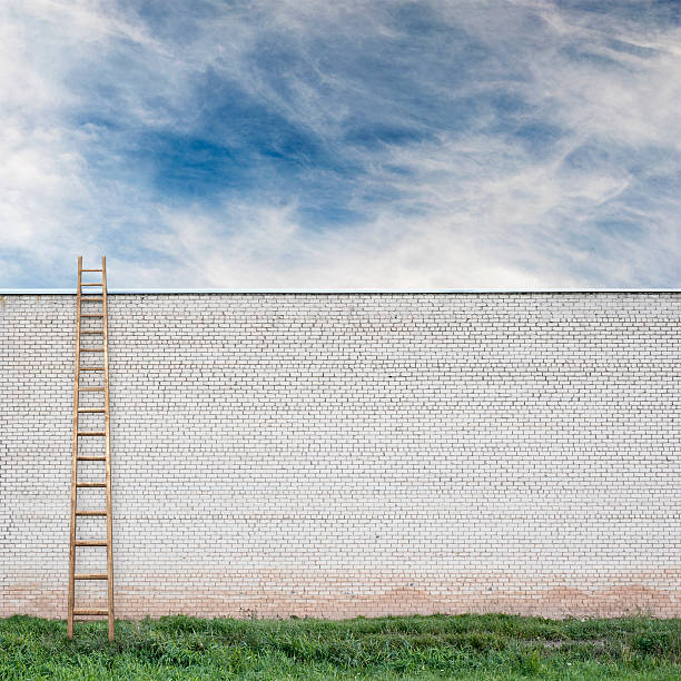 istock Blue sky behind the huge wall with a wooden ladder 514797142