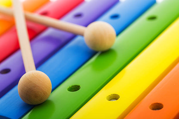 Rainbow colored wooden toy xylophone against white background stock photo