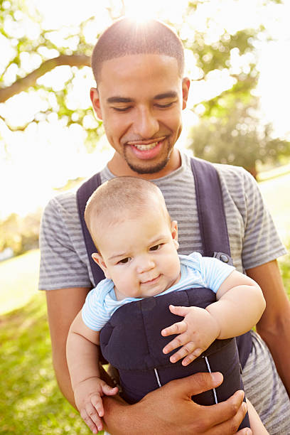 istock Father With Son In Baby Carrier Walking Through Park 514800319