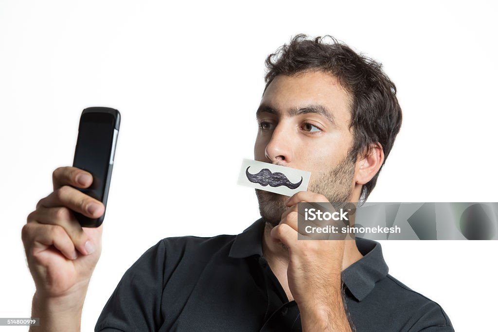 casual man make selfie portrait with fake moustache casual man make selfie portrait with fake moustache,  close composition isolated Movember Stock Photo