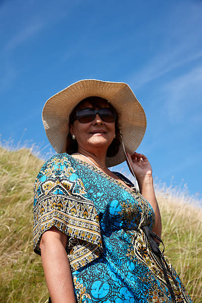 istock Mature smiling woman standing on grassy headland 514801671