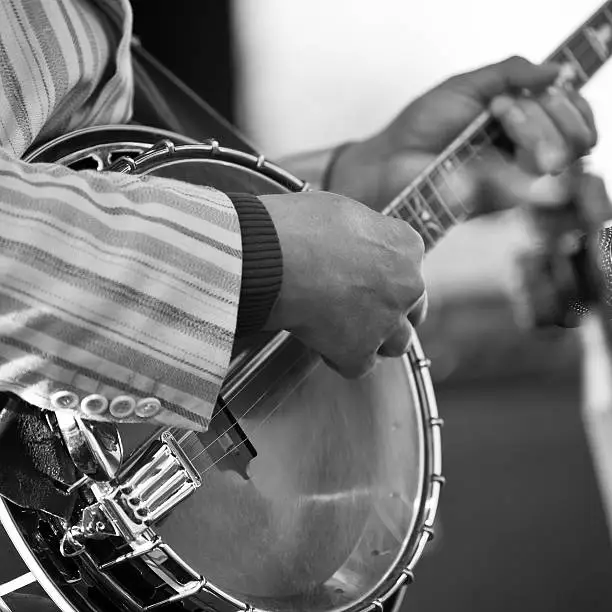 Hands of the man playing the banjo in black and white