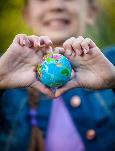 istock girl holding globe in hands folded in shape of heart 514802873