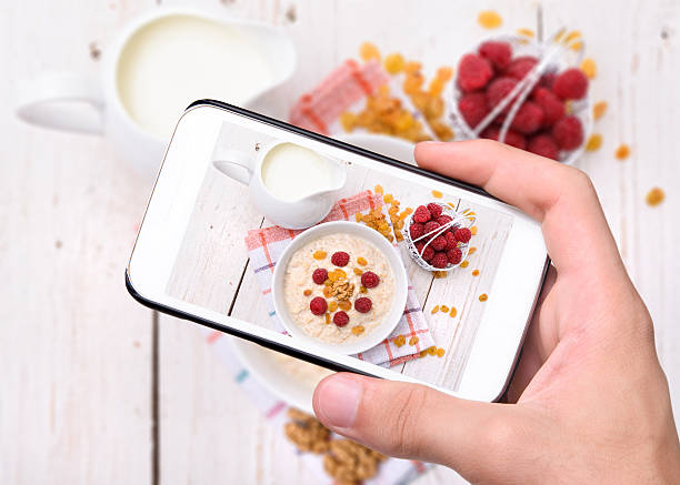 mano tomando fotografías de avena con teléfono inteligente - oatmeal porridge oat raisin fotografías e imágenes de stock