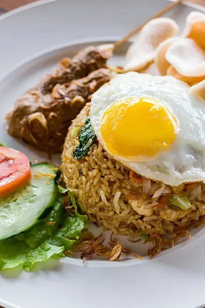 A popular fried rice dish in Indonesia and Malaysia. Served with egg, chicken satay, prawn crackers and salad garnish.