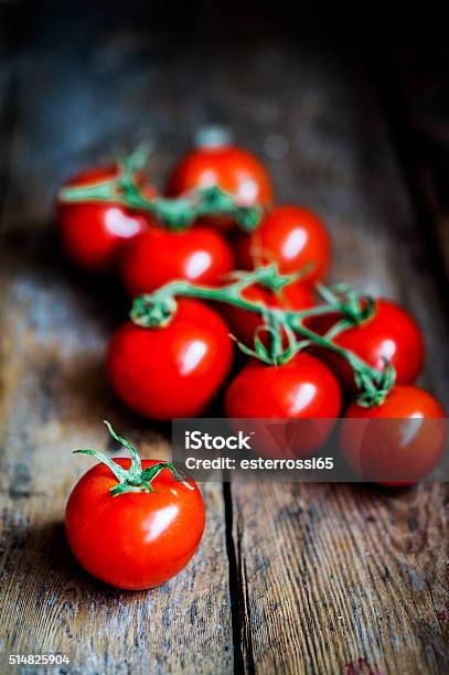 Tomatoes On The Vine On Rustic Wooden Background Stock Photo - Download Image Now - Agriculture, Autumn, Backgrounds