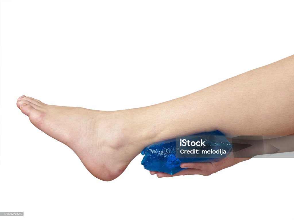 Acute pain in ankle. Acute pain in a woman ankle. Woman holding hand to spot of ankle-aches. Adult Stock Photo