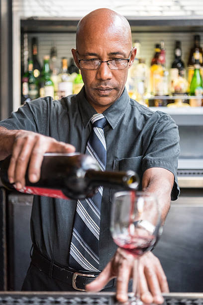 Bartender serving a glass of red wine