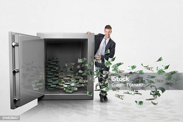 Hombre de negocios con dinero en caja fuerte grande sobre fondo