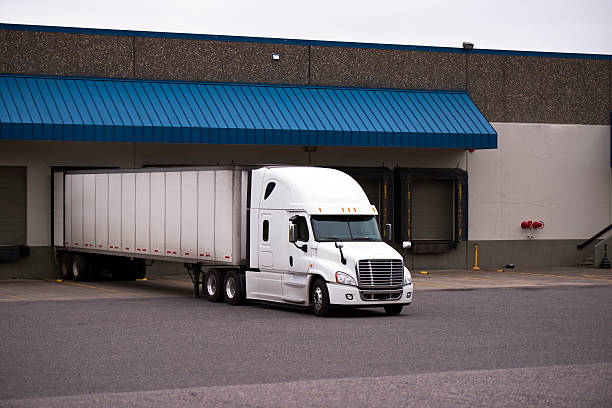 istock White truck with a trailer in a warehouse on the unloading 514828673