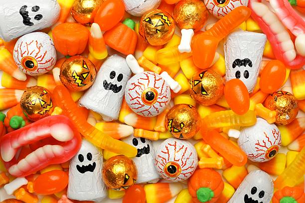 Halloween candy background Halloween background of mixed candies, orange color theme halloween candy stock pictures, royalty-free photos & images