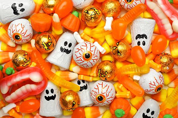 Halloween candy background Halloween background of mixed candies, orange color theme halloween treats stock pictures, royalty-free photos & images