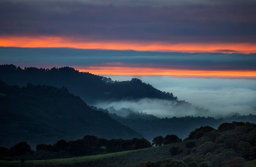 The sun sets beyond the approaching marine layer at Carmel Valley, California