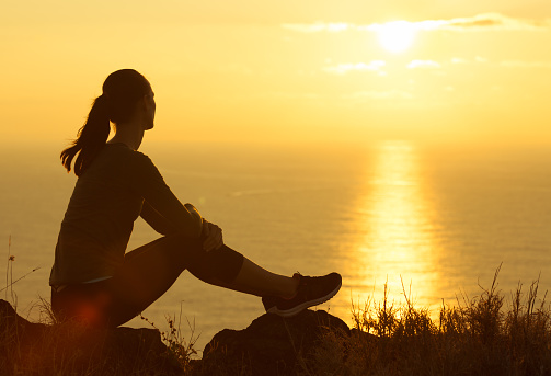 Young woman watching beautiful sunrise in Hawaii.