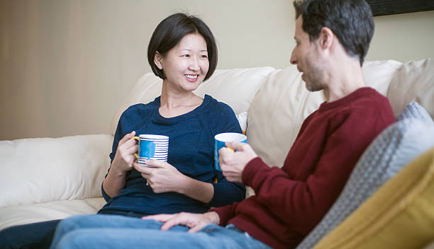 multi-ethnischen familie caucaian mann und koreanische frau, wie zu hause fühlen. - pair couple mid adult happiness stock-fotos und bilder