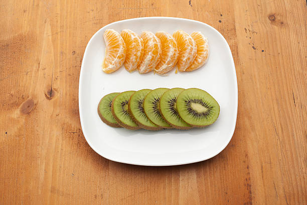 istock fresh fruit with kiwi and tangerines on white plate 514832473