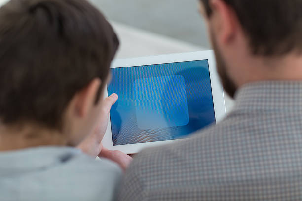 istock Cute friendly family is entertaining with modern technology 514833984