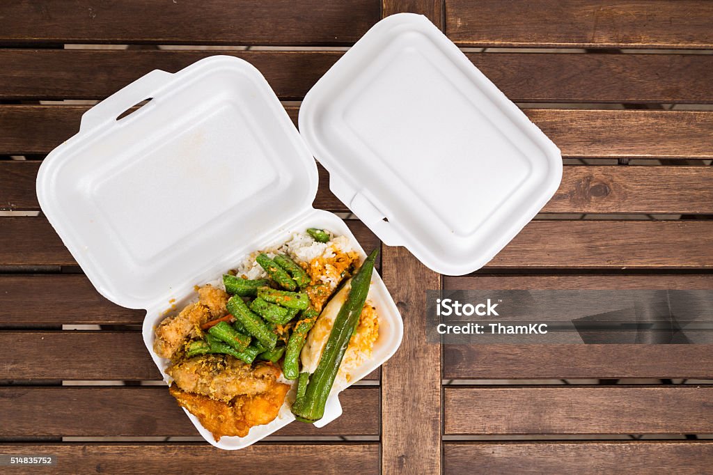 Convenient but unhealthy polystyrene lunch boxes with take away Convenient but unhealthy polystyrene lunch boxes with take away meal on wooden table Take Out Food Stock Photo