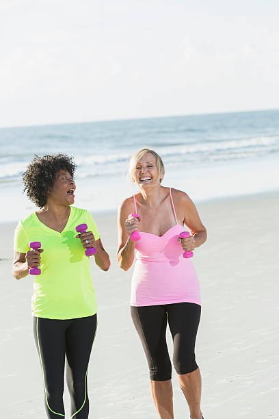 istock Two mature women exercising on beach with handweights 514836868