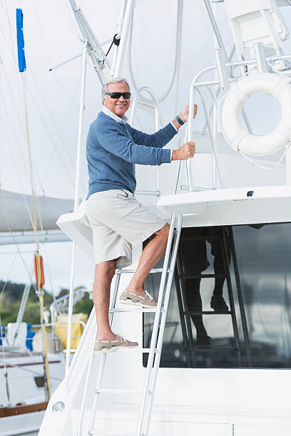 istock Senior man climbing on his boat, bright sunny day 514837022