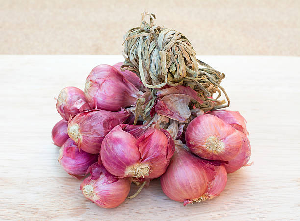 istock Red onions on wooden background 514838672