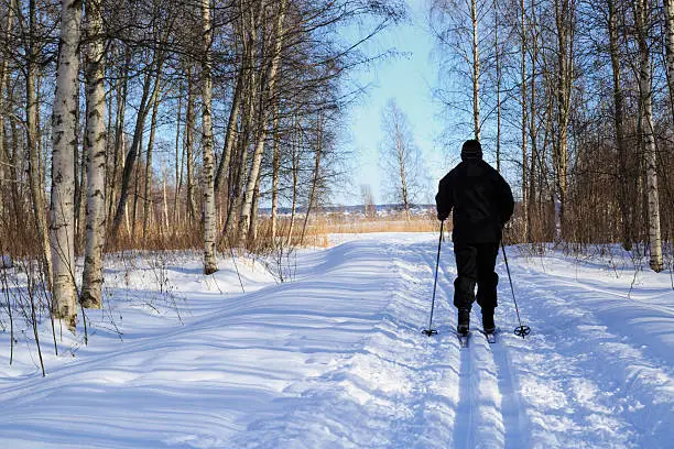 Woman cross country skiing in late winter with a low solstice