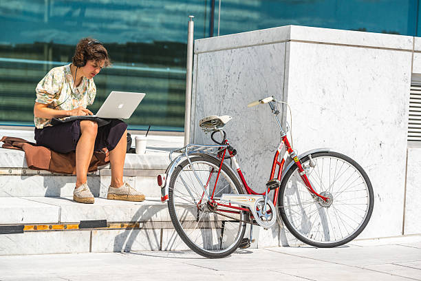 kobieta działa na laptopie siedzi w pobliżu oslo opera house - macbook zdjęcia i obrazy z banku zdjęć