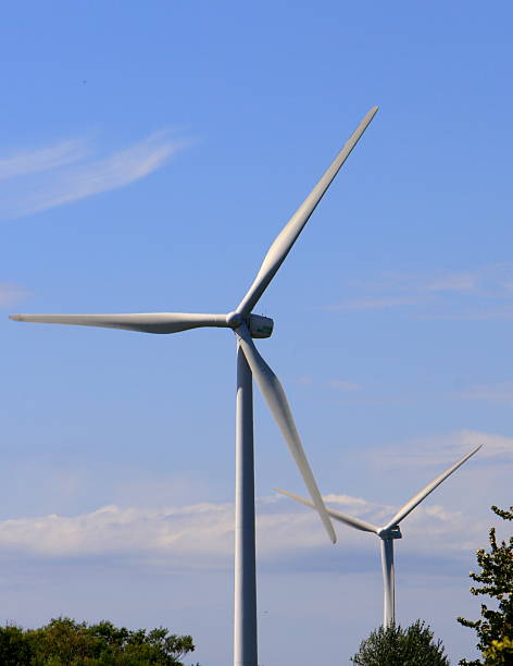 istock Clean energy white wind turbine in green field 514845498