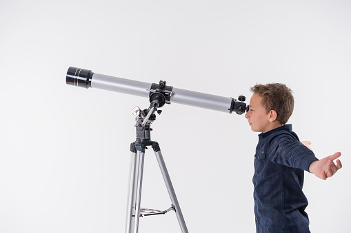 Young boy with astronomy telescope,studio