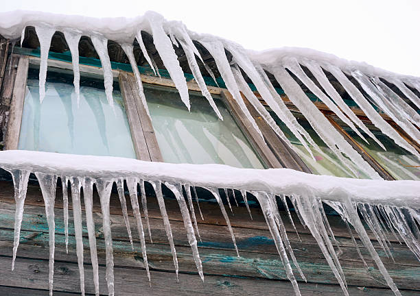 istock Long, sharp icicles dangle dangerously from  roof of the house 514850994