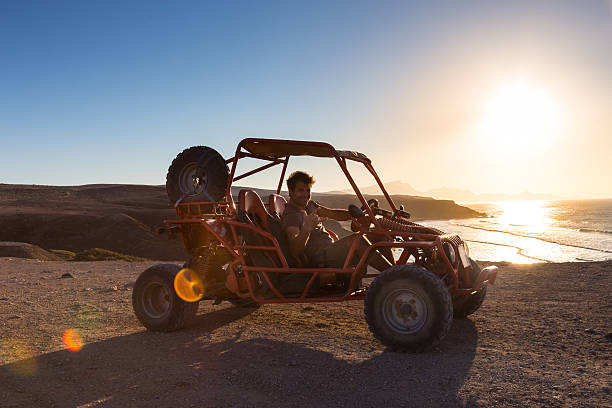 człowiek jazdy quad o zachodzie słońca. - beach buggy zdjęcia i obrazy z banku zdjęć