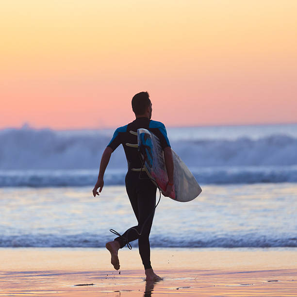 istock Silhouette of surfer on beach with surfboard. 514852158