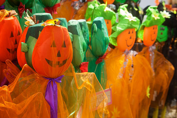 Rows of headed pumpkin faces with green and purple ribbons.
