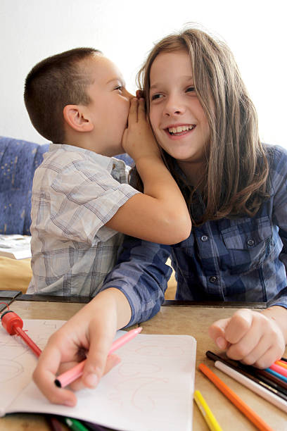 istock Boy whispering into girl's ear 514853157