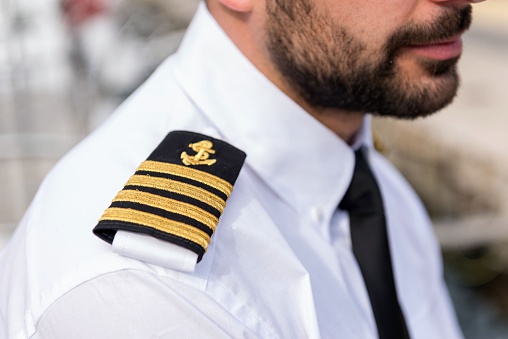 Horizontal color image of young boat captain, close-up of shoulder epaulette.