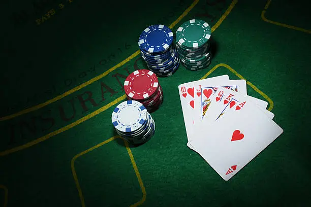 Cards and chips for poker on green table, top view.