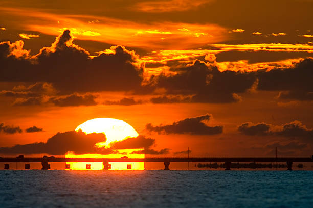 Sanibel Causeway Sunset Using a long lens and taken from Fort Myers Beach.  The causeway connects the mainland with Sanibel Island, Florida. fort myers beach photos stock pictures, royalty-free photos & images