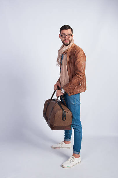 istock Young man in a brown jacket with a travel bag 514856142
