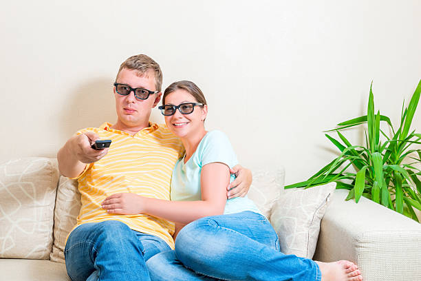 istock couple watching TV in 3d glasses on the couch 514857204