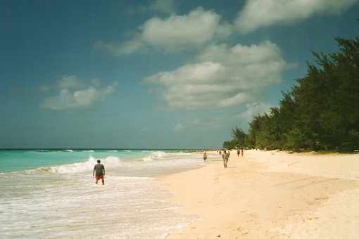 Maxwell Beach, Barbados - February 26, 2006: Tourists walking and refreshing at Maxwell beach, a long stretch of white sand  on Barbados southern coat.