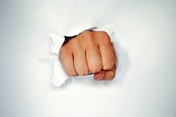 istock Fist breaking through a white paper isolated on white 514875341