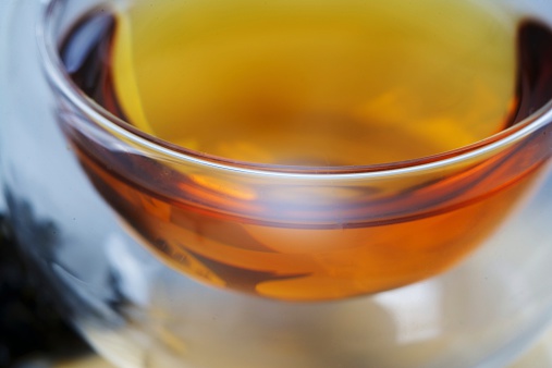 photo close up glass cup of golden tea