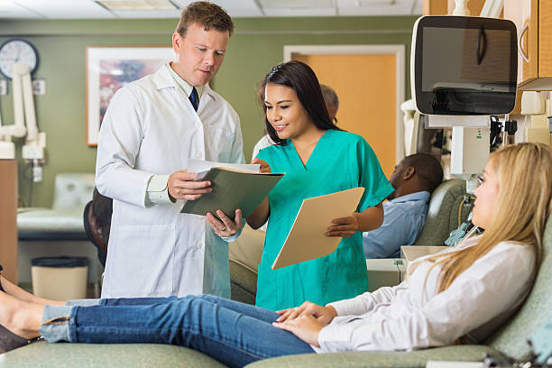 istock Phlebotomist and nurse discussing patient chart as she donates blood 514876381